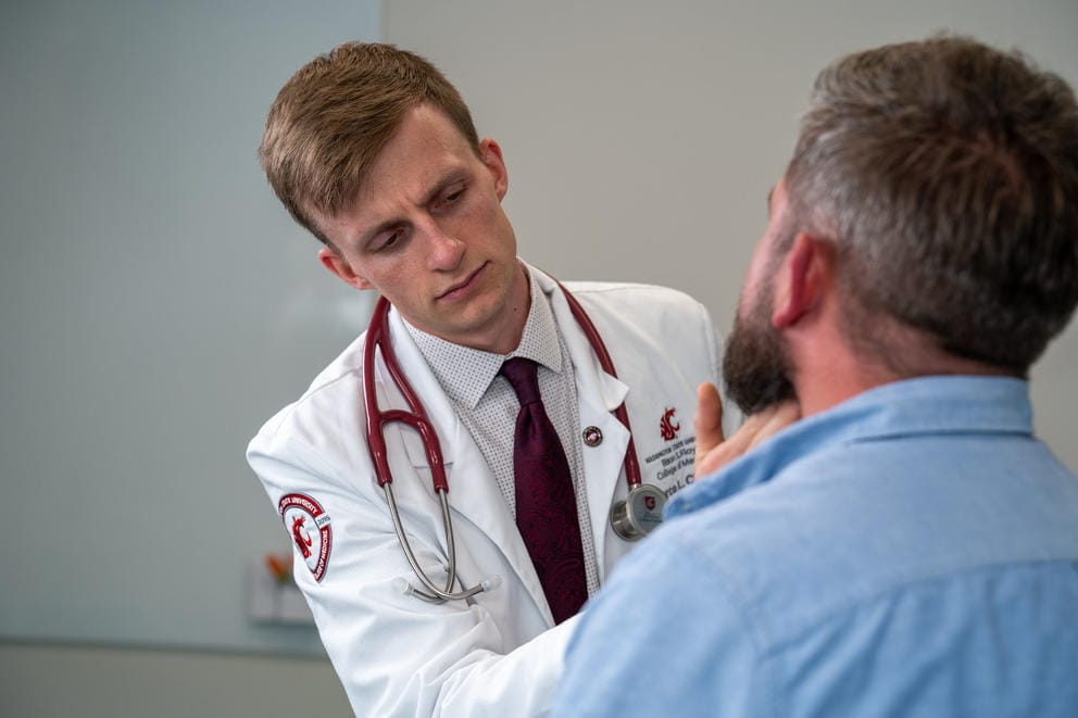 A young doctor examines a patient