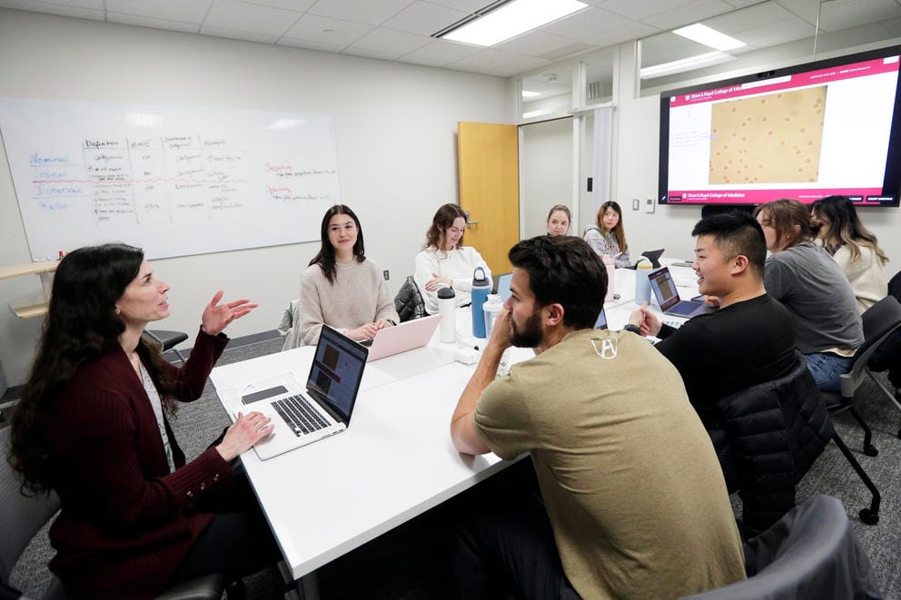 A small group of students sit around a conference table