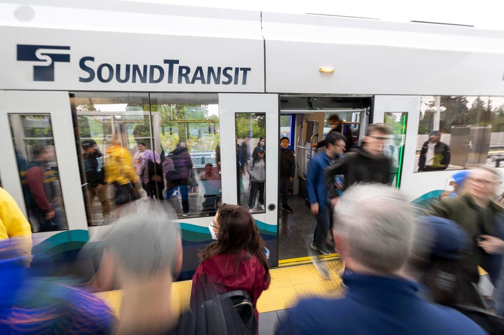 People crowd onto a train that says