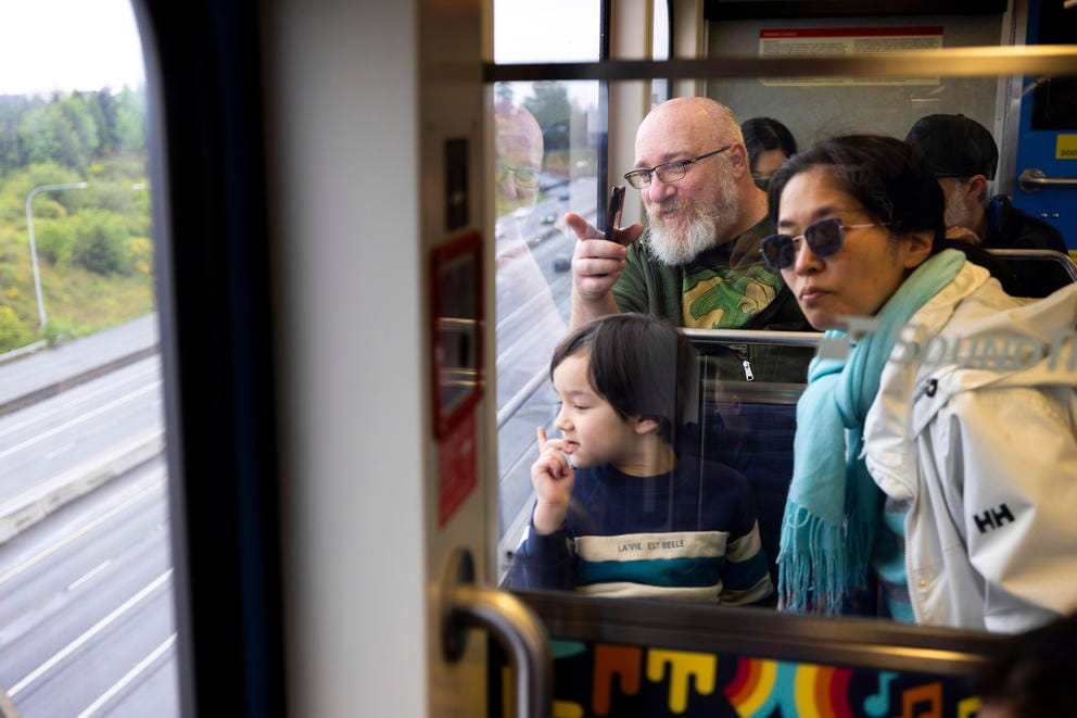 People look out a window of a train