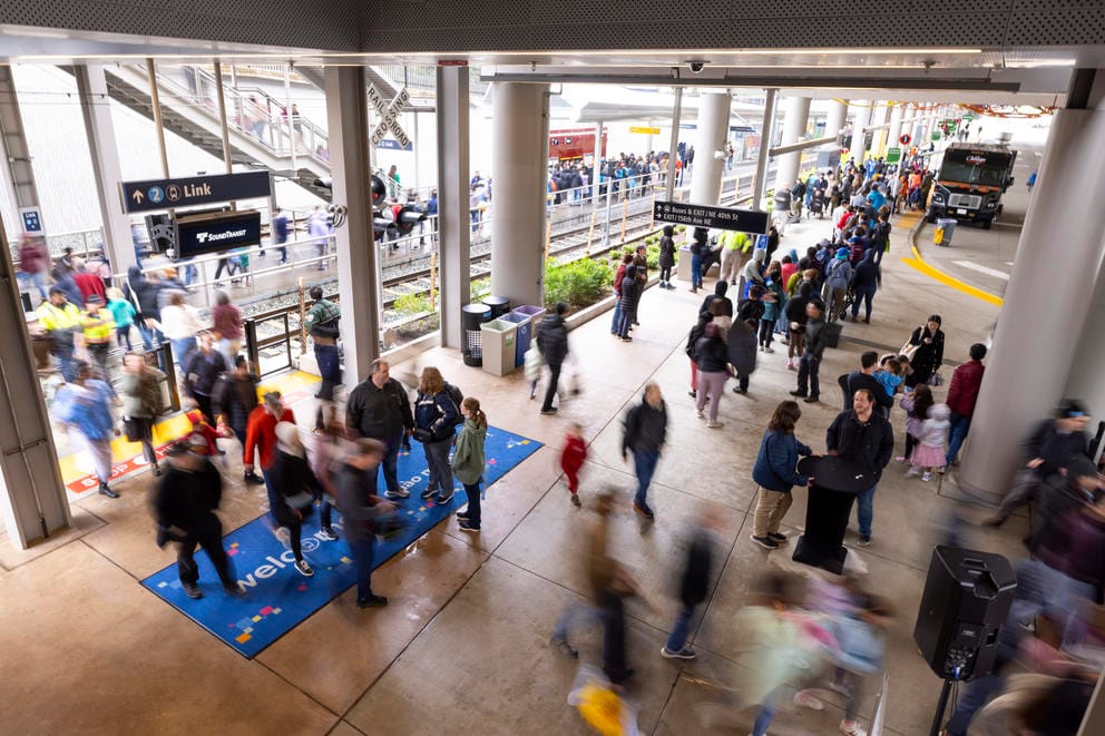 People mill around a train station.