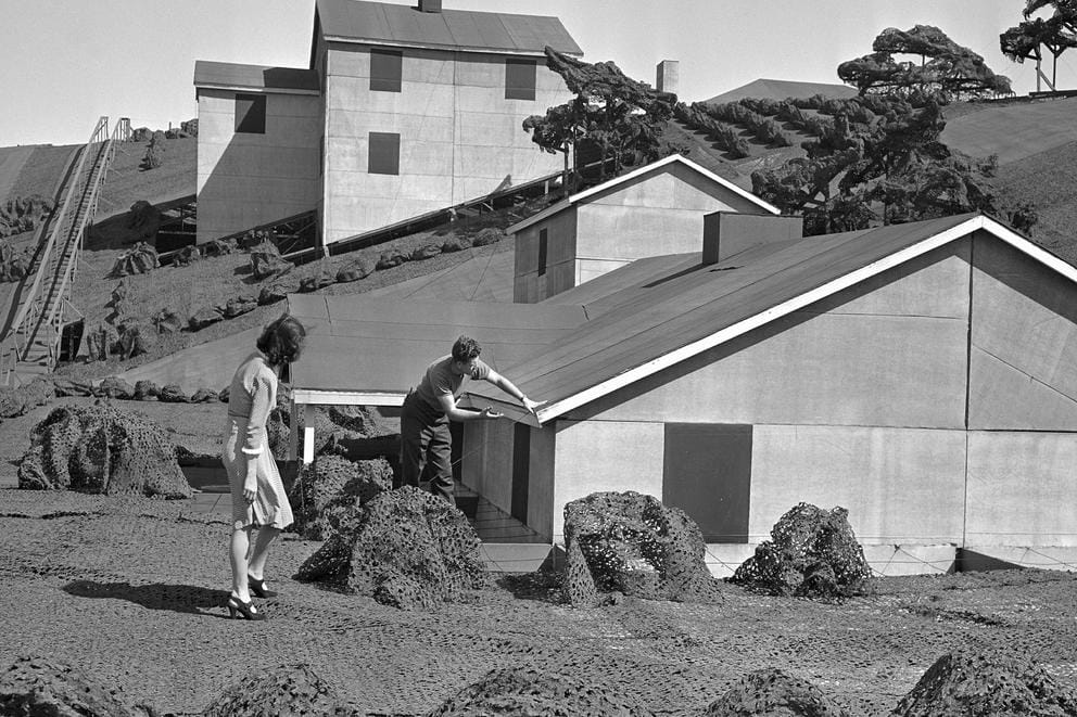 Two people look a fake house.