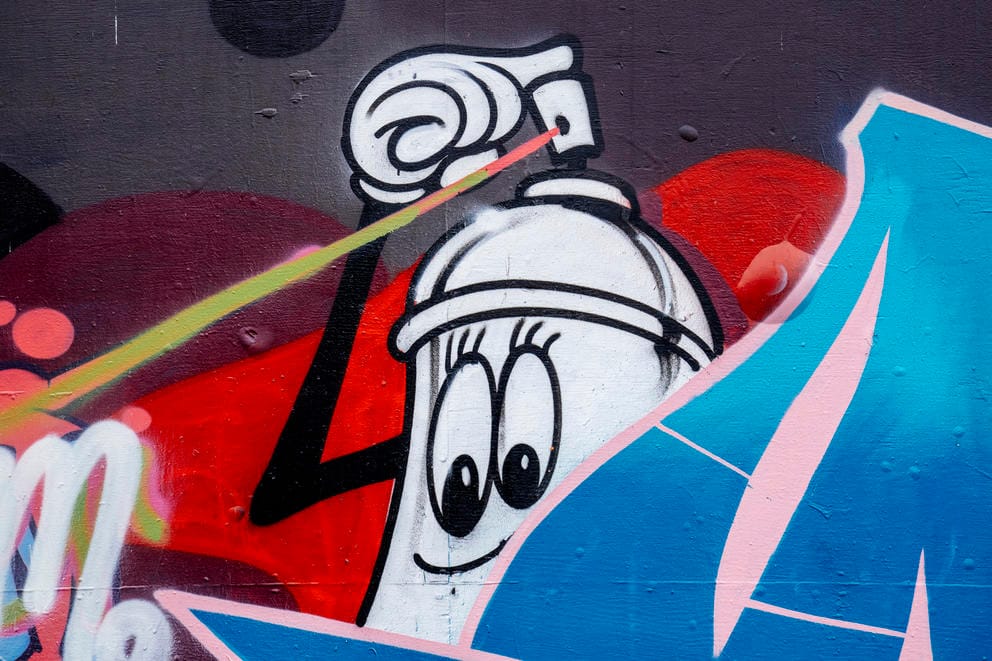 A detail of a spray can character in a graffiti piece