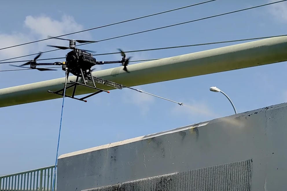 A graffiti drone paints a gray wall