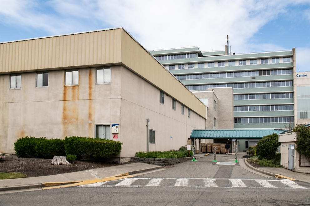 Building 18, an aging tan structure, sits on the VA Puget Sound campus