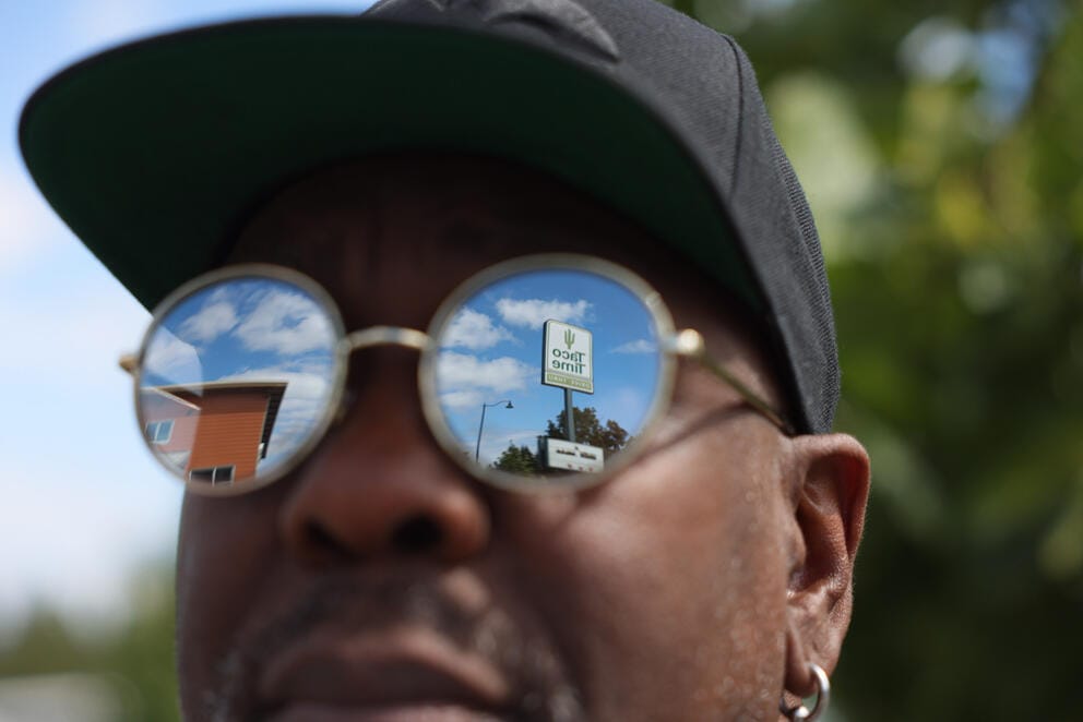 The sign of the Shoreline Taco Time is reflected in the sunglasses of Seattle music artist Michael “Wanz” Wansley