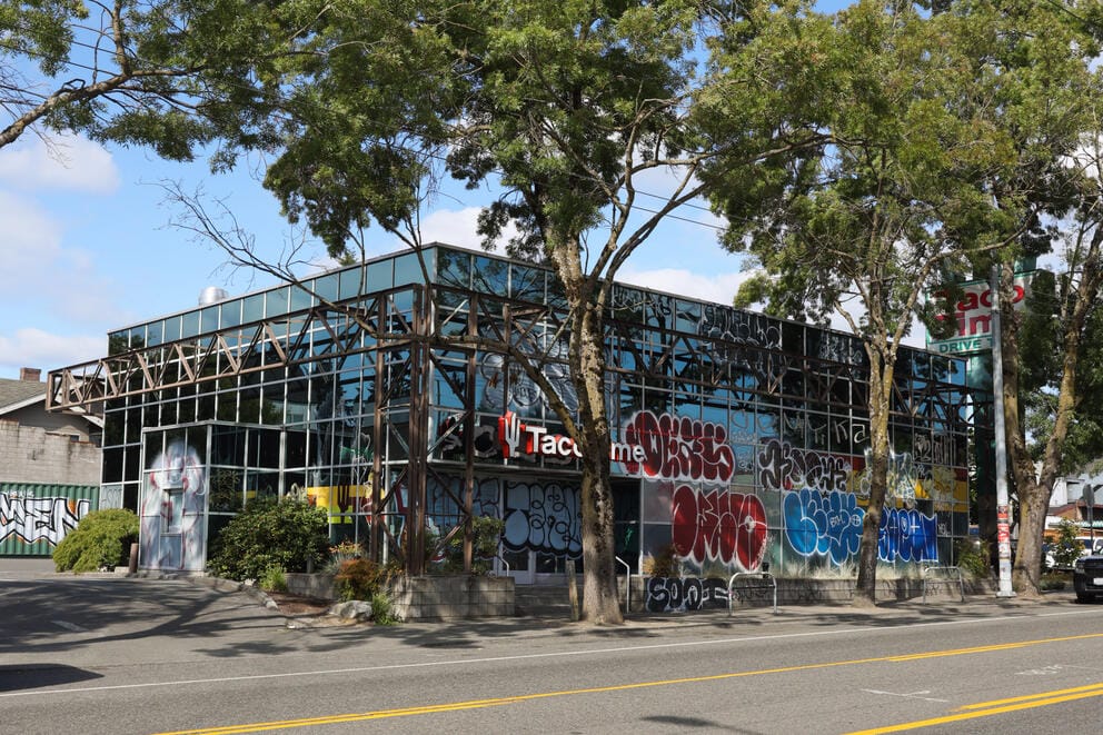 The exterior of the Wallingford Taco Time, the building is glass and covered in graffiti