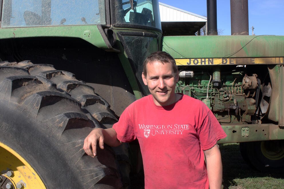 Hay farmer Jon Driver standing in front of a tractor