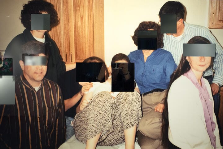 An old photograph of people with blurred gray bars in front of their eyes.