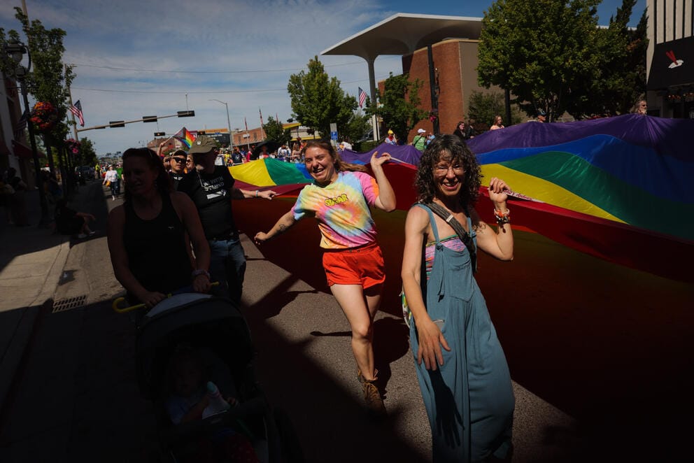 People carry a giant Pride flag in the Yakima Pride Parade