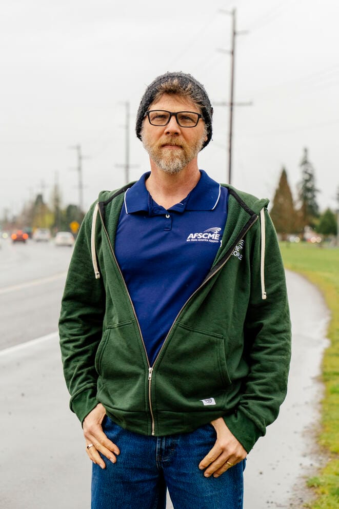 A man poses for a portrait on the side of a street