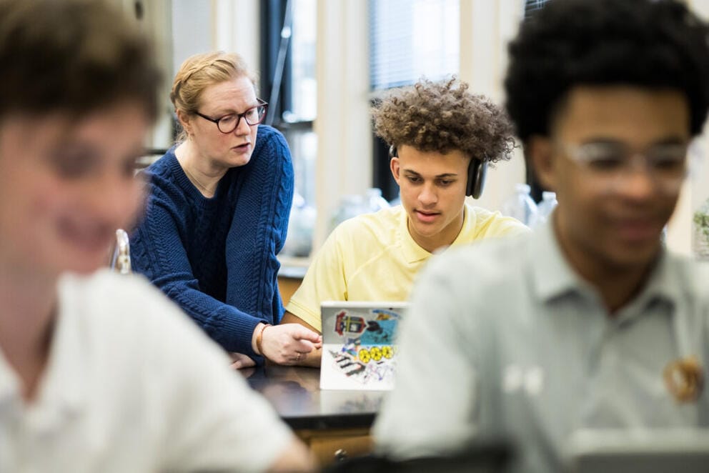 A teacher helps a student during a biology class