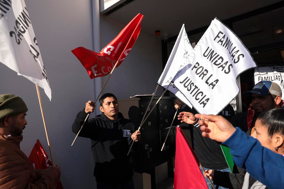 Farmworker organizer Alfredo “Lelo” Juarez hands out flags as farmworkers