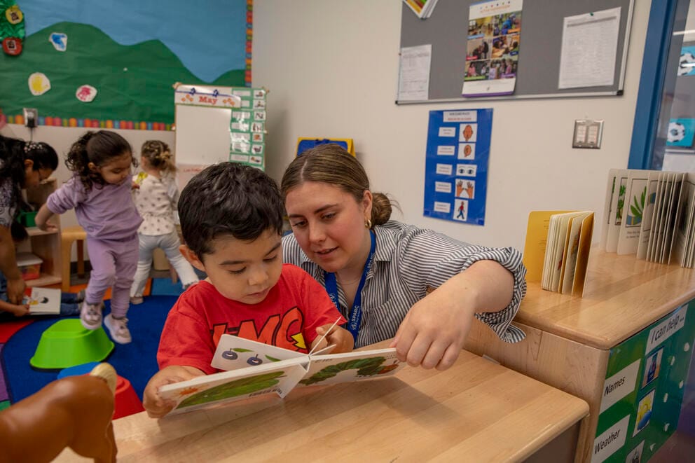 A teacher reads to a child.
