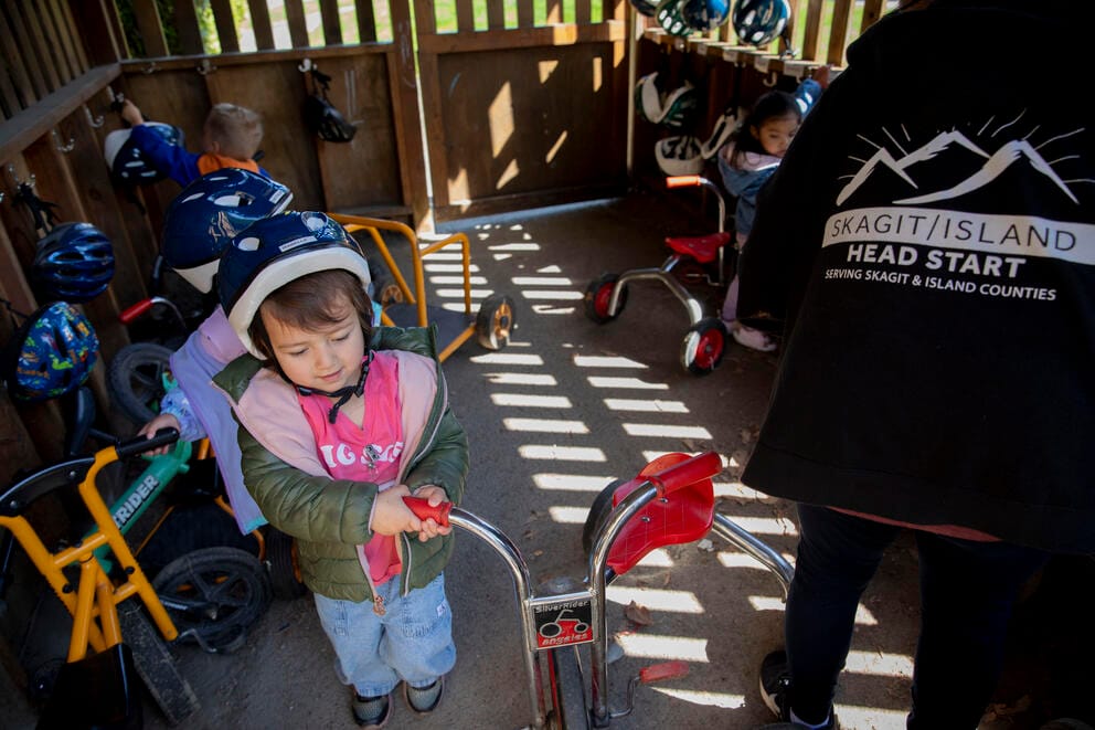 A child prepares to ride a bike.