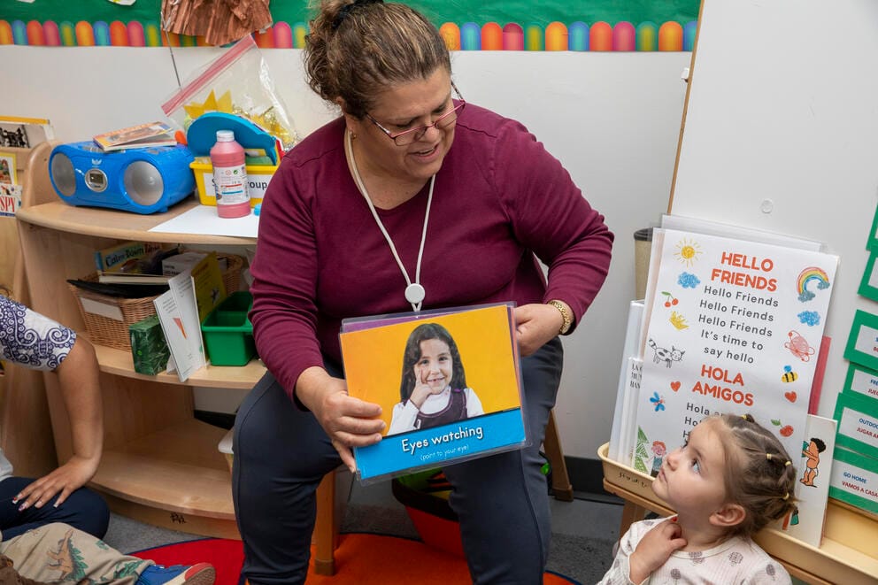 A teacher reads to a group of children.