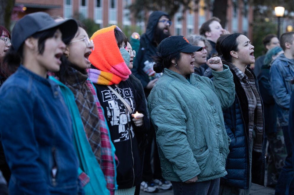 A crowd of people sings together.