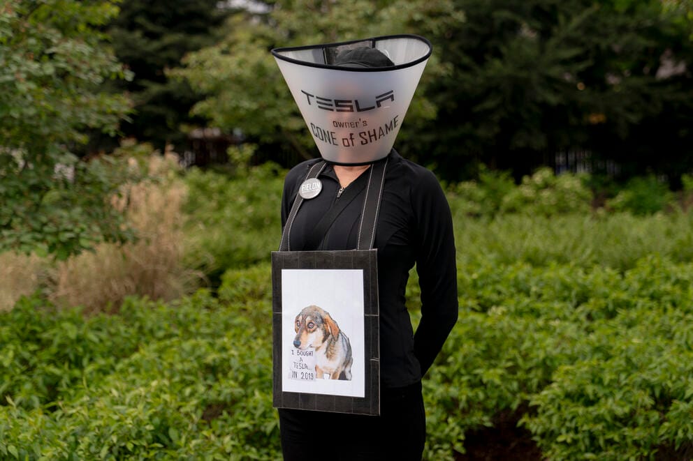 A person wears a pet recovery cone labeled 