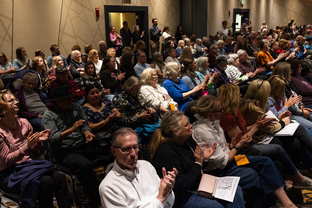 Audience members applaud during a town hall