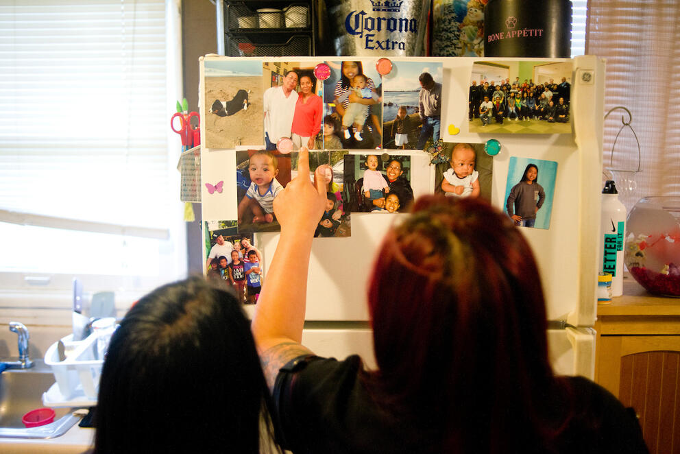 Bopha Khliu, right, looks at pictures of her father, Sun Khliu, with her daughter, Angeliyah Khliu, 13, at their home in Portland.