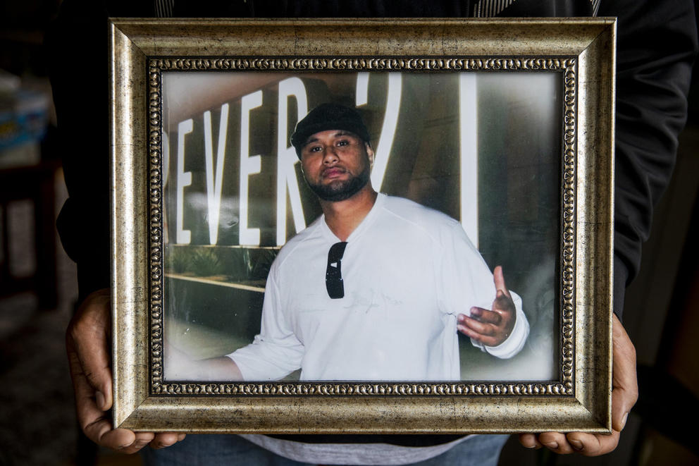 Hands holding a framed photo of Iosia Faletogo