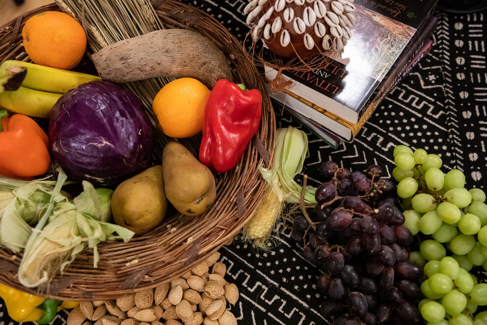 A bowl of fruits and vegetable including grapes, peppers, bananas, pear and cabbage
