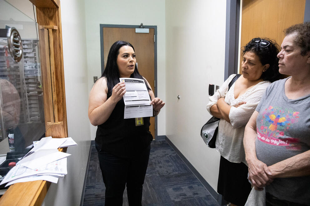 A woman showing a ballot to prospective voters