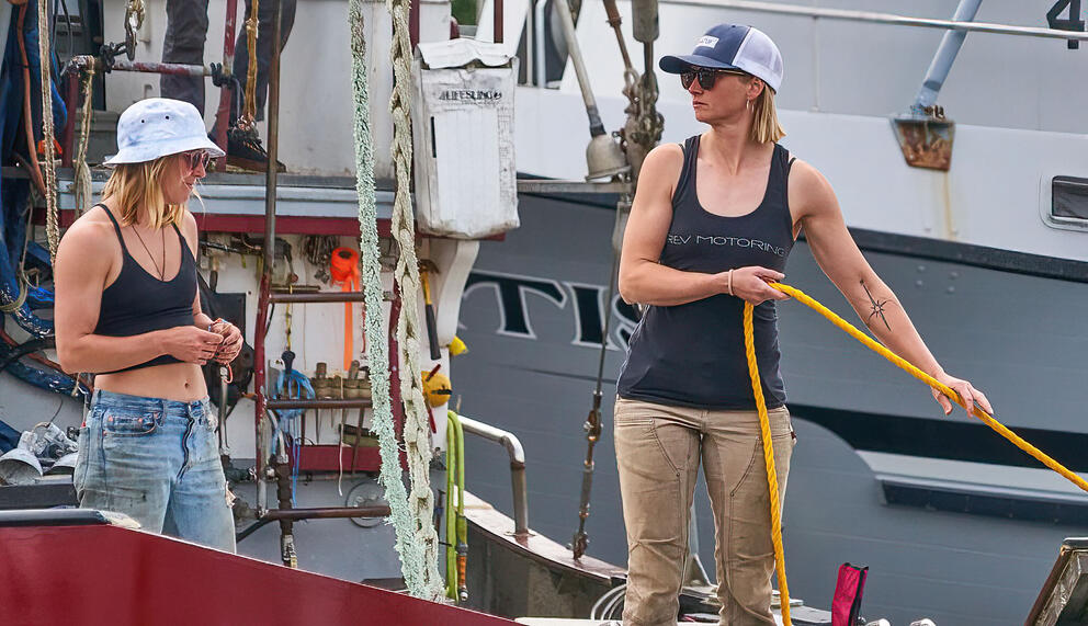 two women working together on a fishing boat