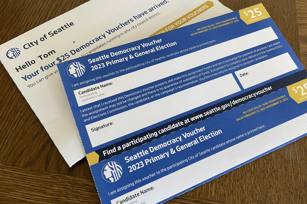 a "democracy voucher" and envelope placed on a table