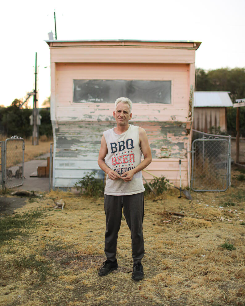 James Williams stands in front of his home in White Dove mobile home park, paint peels on the trailer