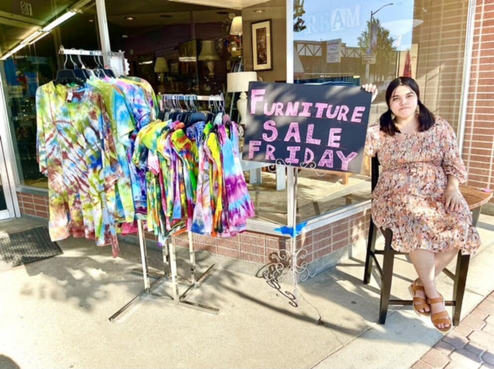 Kit Nelson-Mora sells furniture at their mom’s thrift store, The Storehouse Merchantile, in Omak, Wash., in the summer of 2021.