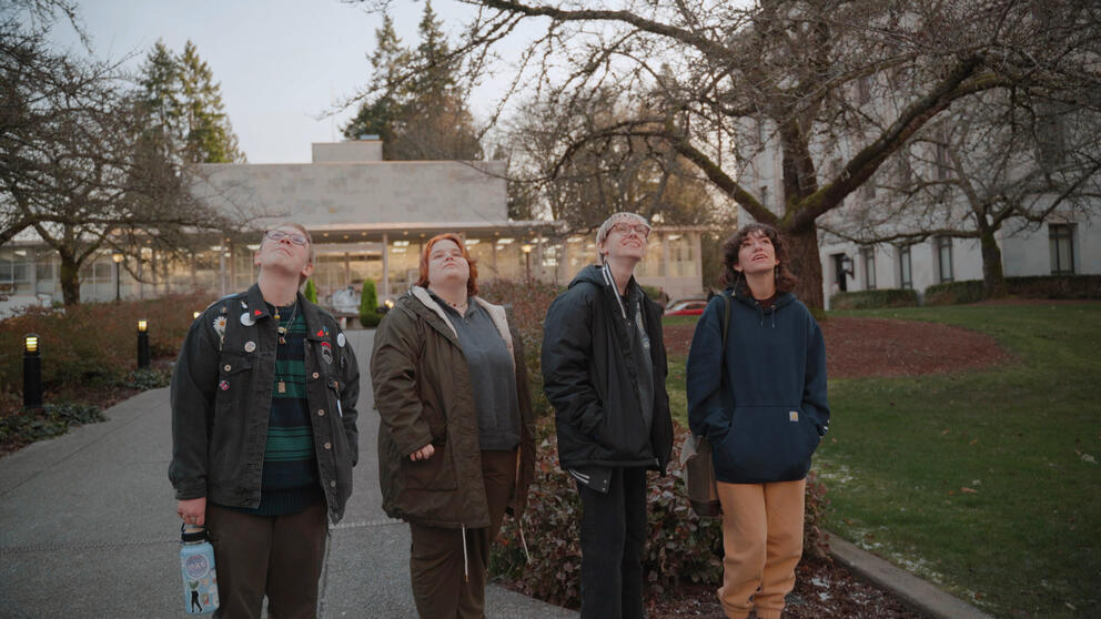 Four people pose on the sidewalk at the Capitol Campus in Olympia.