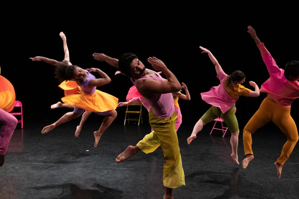 a group of dancers on stage in unison dressed in candy colored costumes