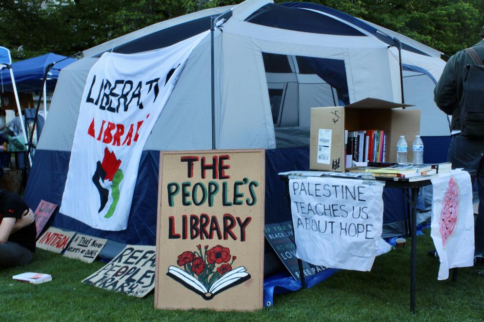 Signs sit outside of the encampment library tent on the University of Washington campus 