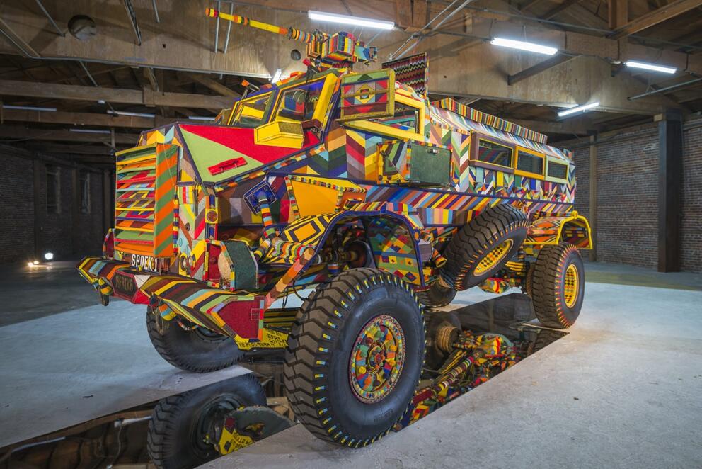 photo of a tank-like vehicle that has been completely covered in colorful beaded panels