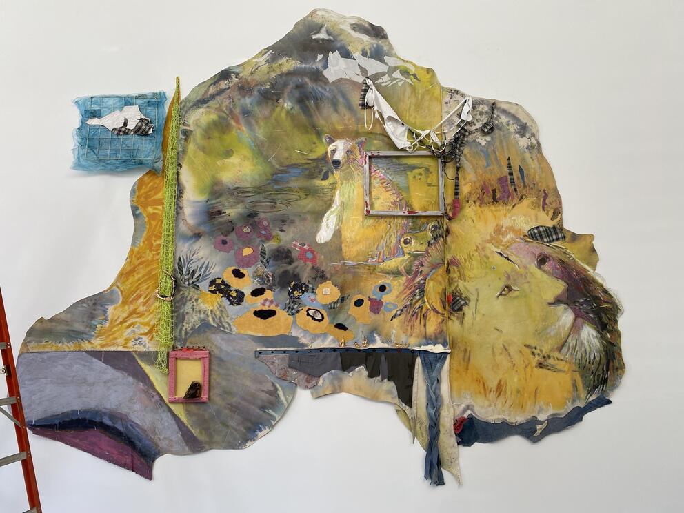 a wall hanging with yellow background and animal faces emerging