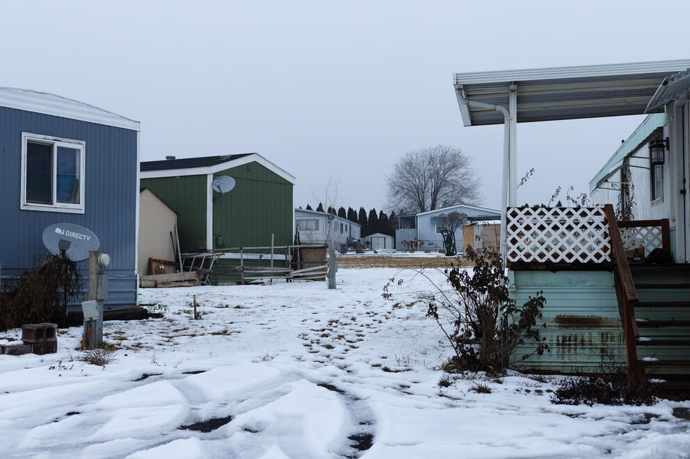 A row of mobile homes sit on fresh snow.