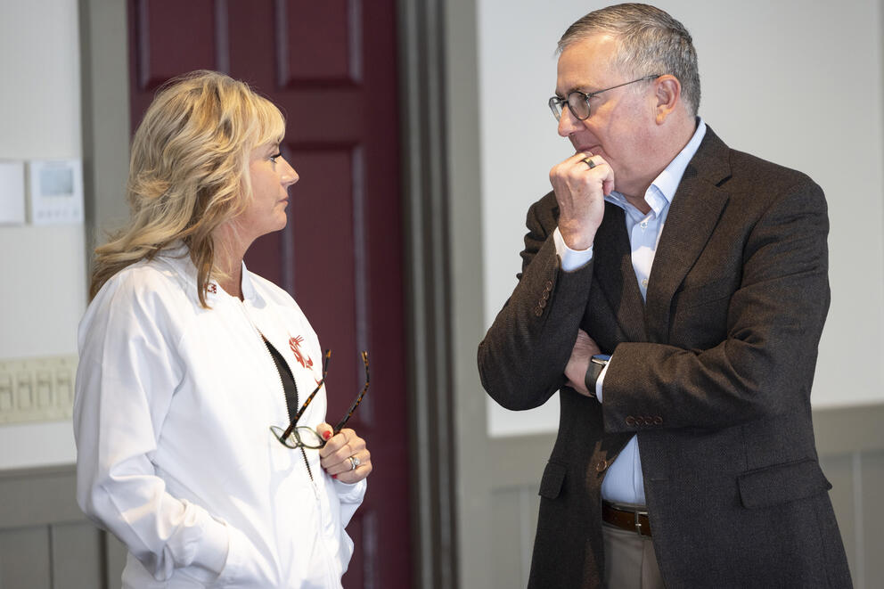 WSU president Kirk Schulz (right) speaks to past Chair of the Board Marty Dickinson during the November 2024 Board of Regents meeting