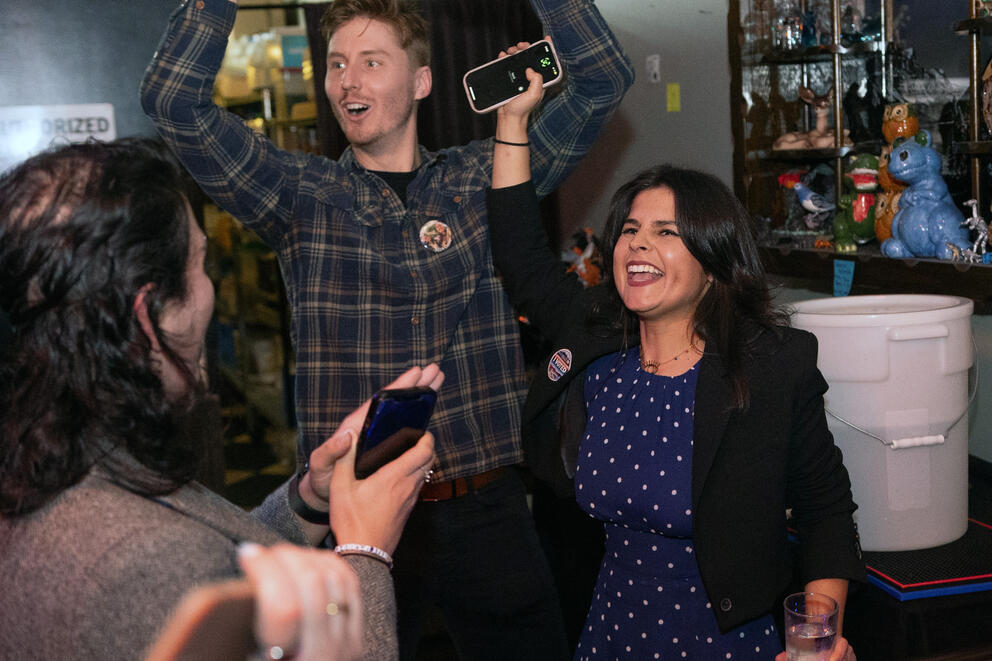 a woman and a man stand together cheering