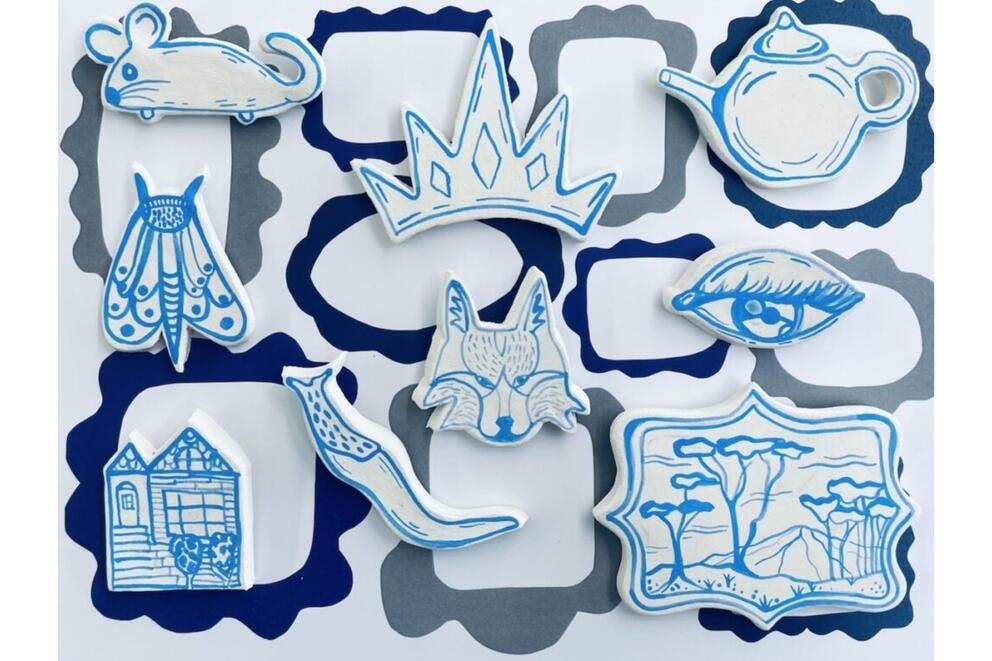 little blue and white ceramic pieces in the form of an eye, teapot, home, moth, etc