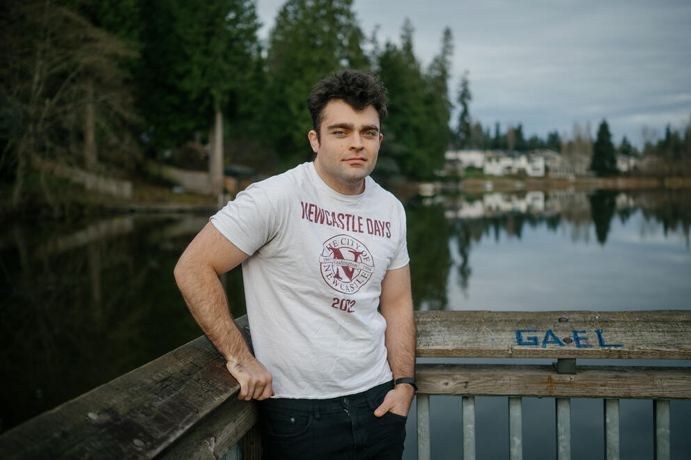 Newcastle City Councilmember Paul Charbonneau, 27, poses for a portrait at Lake Boren Park wearing a Newcastle t-shirt.
