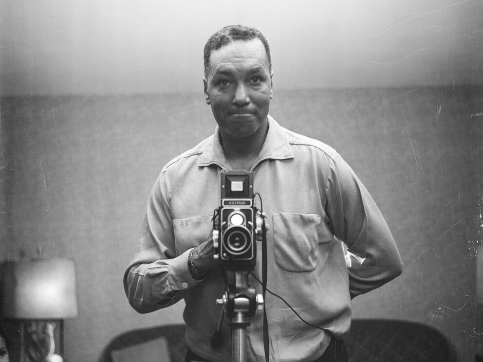 black and white midcentury photo of a man taking a photo of himself in a mirror
