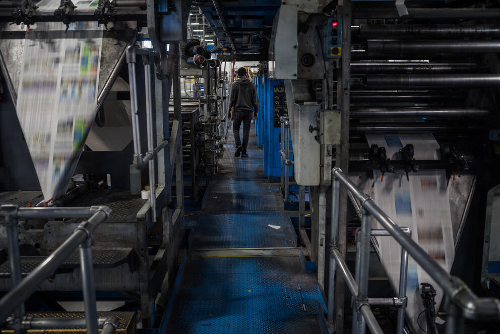 A pressman walks past the newspaper press